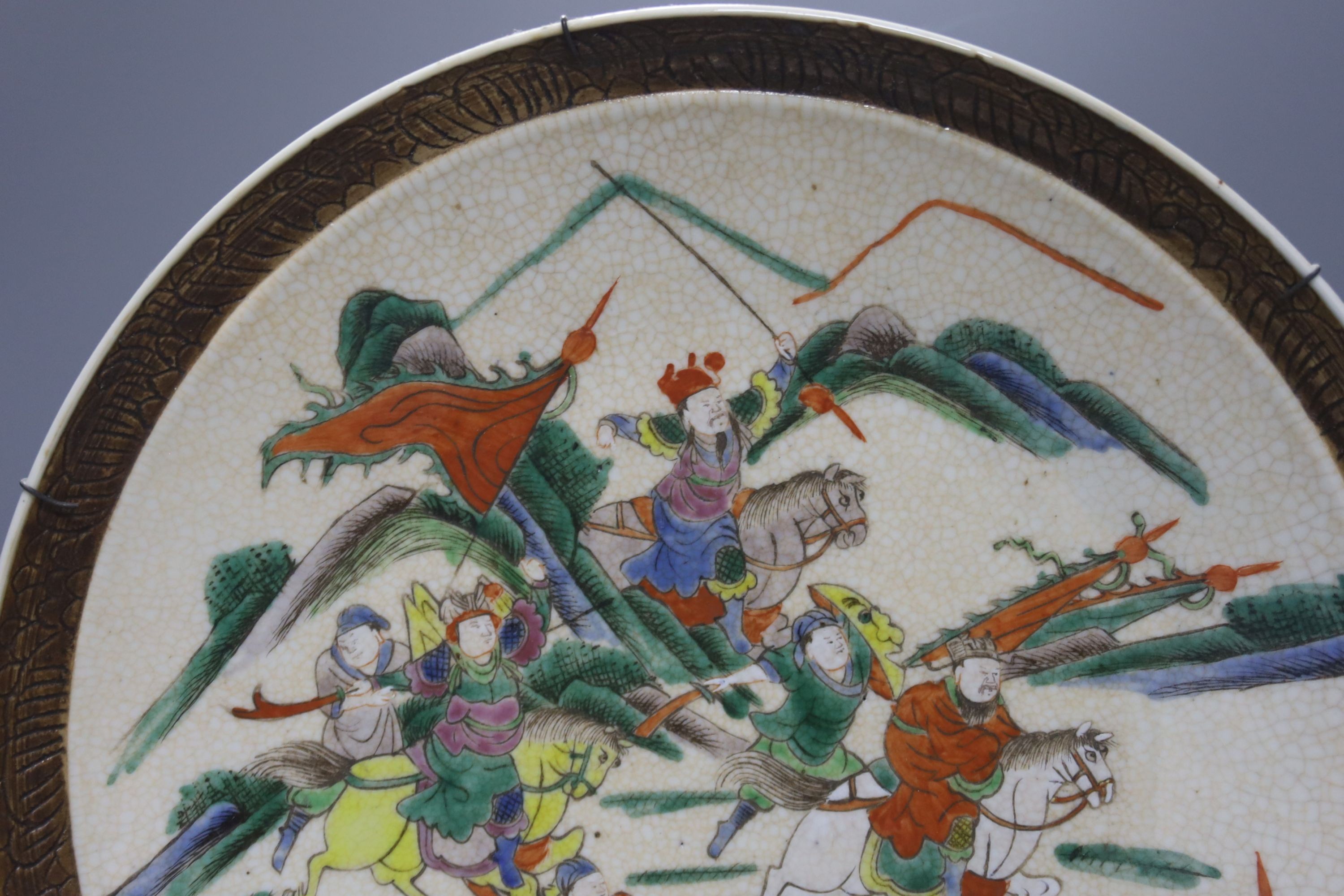 A Chinese crackle glaze dish, early 20th century, depicting a battle scene 33cm